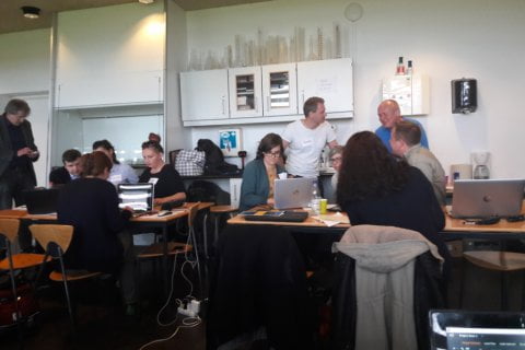 Zdjęcie z warsztatów, dwie grupki osób rozmawiają ze sobą