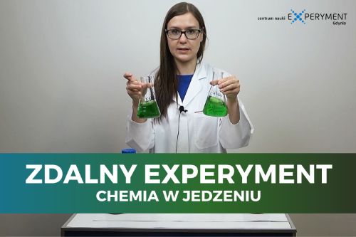 Zdalny experyment, chemia w jedzeniu. Edukatorka trzyma w dłoniach dwie kolby z zieloną substancją.
