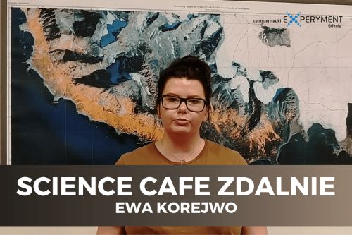 Science cafe zdalnie. Ewa Korejwo stoi na tle mapy Arktyki. Ma ciemne związane włosy, okulary w ciemnych oprawkach i brązową bluzkę.