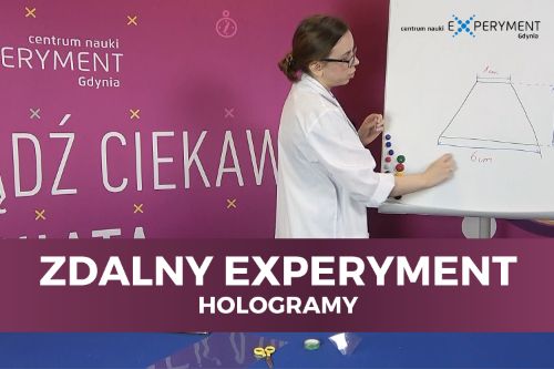 Zdalny experyment, hologramy. Edukatorka stoi przy tablicy z narysowanym trapezem.