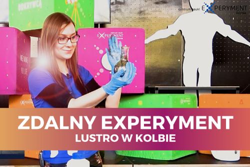 Zdalny experyment, lustro w kolbie. Edukatorka trzyma w dłoniach szklaną kolbę, w której znajduje się srebrzysta substancja.
