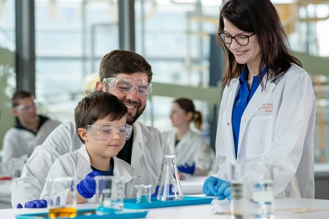 Zdjęcie kobiety, mężczyzny i dziecka podczas warsztatów chemicznych