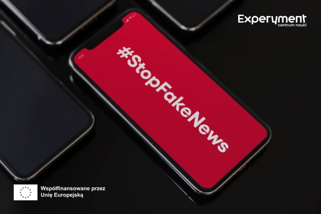 Telefon z wyświetlonym na czerwonym tle napisem #StopFakeNews. W lewym dolnym rogu flaga Unii i napis "Współfinansowano przez Unię Europejską". W prawym górnym rogu - logo Experymentu.