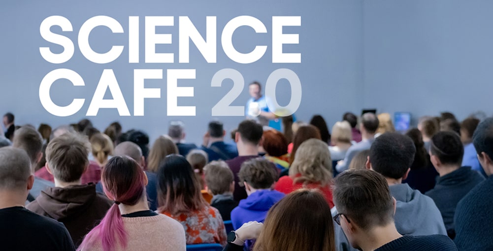 sala pełna ludzi, w tle wykładowca, napis SCIENCE CAFE 2.0.