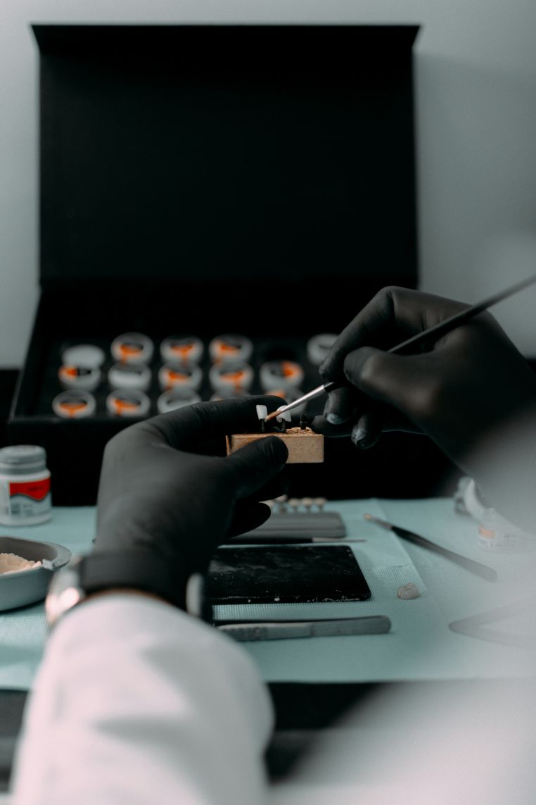 Dłonie w czarnych gumowych rękawiczkach przeprowadzające eksperyment w laboratorium