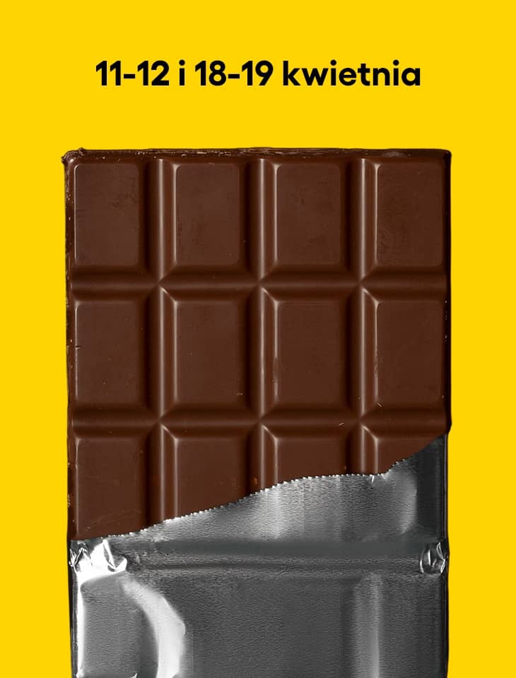 Tabliczka mlecznej czekolady częściowo wysunięta z srebrnego opakowania na intensywnie żółtym tle. Na górze czarny napis: 11–12 i 18–19 kwietnia