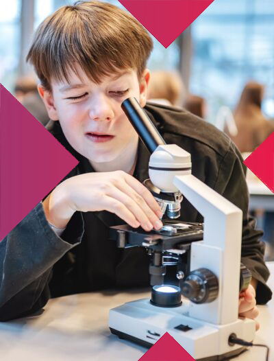 zdjęcie chłopca który patrzy przez mikroskop