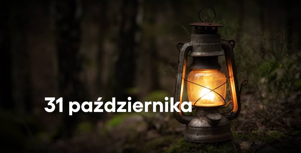 Na ciemnym tle przedstawiającym leśne poszycie stoi stara, metalowa lampa naftowa z zapalonym płomieniem. Ciepłe, pomarańczowe światło rozświetla lampę i otaczającą ją roślinność. Po lewej stronie widnieje biały napis „31 października”.